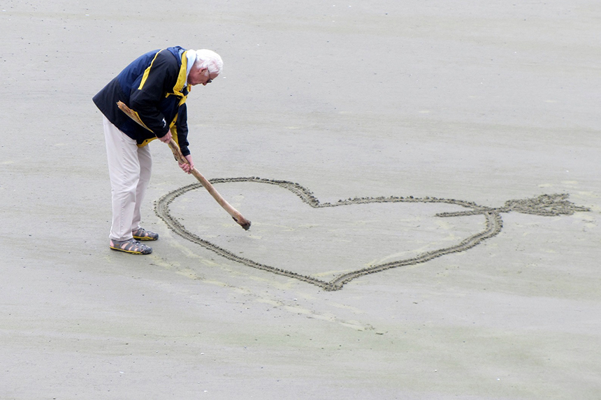 Imagem de um idoso a desenhar um coração 
